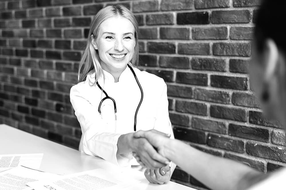 Happy doctor and patient shaking hands