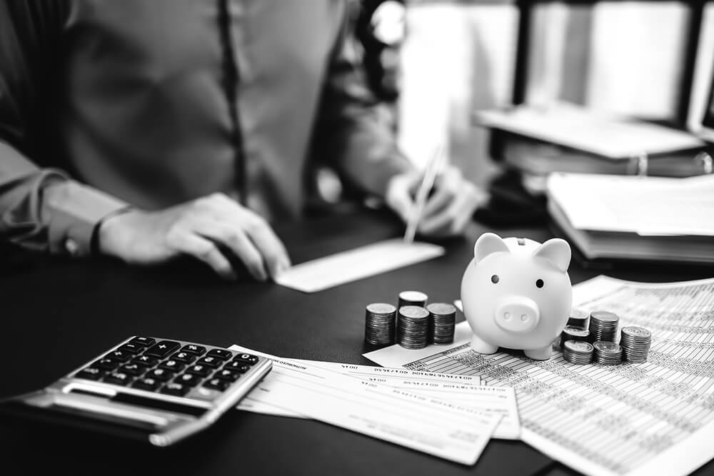 person calculating money with piggy bank